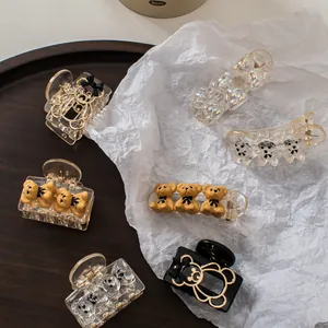 Chic champagne bear hair claws in various finishes and sizes on an artistic backdrop