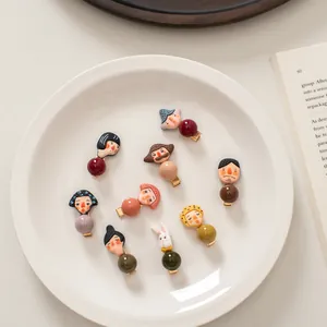 Set of 9 cute cartoon character hair clips with colorful round beads on a ceramic plate