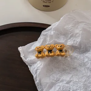 Detailed view of champagne bear hair claw clips on a minimalist aesthetic background