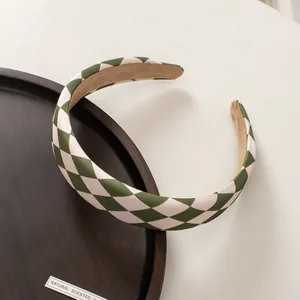 Close-up of green and white checkerboard fabric headband with soft anti-slip brown lining