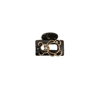 Champagne bear hair claw clip with black bow on minimalist white background