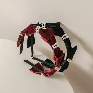 Detalle de diademas de terciopelo rojo y negro con elegantes perlas y lazos
