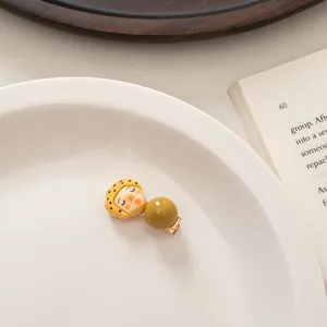 Detailed shot of a cute cartoon hair clip with a beret-wearing doll in a ceramic tray