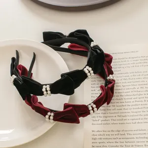 Detalle macro de diademas de terciopelo francés con perlas en negro y rojo vino