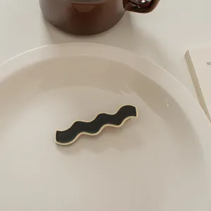Nahaufnahme einer Haarklammer im französischen Wellendesign in Schwarz und Creme-Weiß