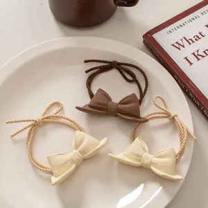 Set of three cute bow hair ties in coffee and cream matte finish with braided ropes