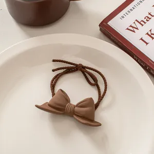 Detail of coffee-colored frosted bow hair tie with durable double-strand elastic rope