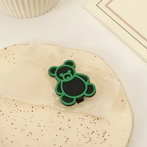 Vista ravvicinata della graziosa molletta per capelli a orso nero e verde su un vassoio