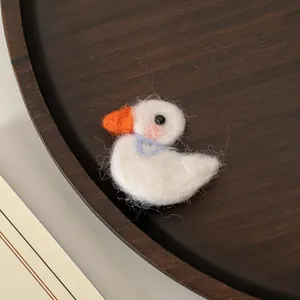 Gros plan sur une pince à cheveux canard en feutre faite main avec texture laine fine