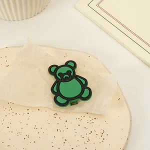 Dettaglio di una graziosa clip per capelli a forma di orso verde opaco su sfondo estetico