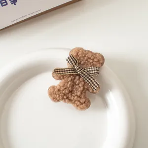 Dettaglio molletta per capelli a forma di orsetto di peluche con fiocco a quadri