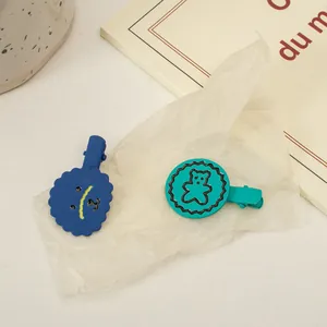 Détail de pinces à cheveux mates avec motifs d'ours de dessin animé bleu et vert
