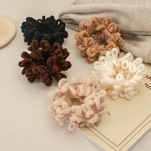 Detail von Plüsch-Haargummis aus Chenille in verschiedenen Farben auf Waffelstoff