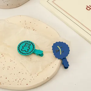 Détail de pinces à cheveux ours mates sur une assiette décorative en porcelaine beige