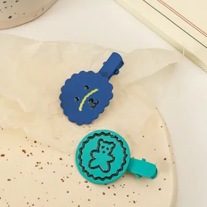 Détail de barrettes à cheveux mates en alliage avec ours sur un plateau à pois crème