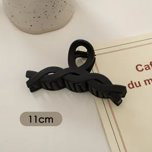 Makro-Detail der 11cm matten schwarzen Haarklammer mit gewebter Textur und Feder