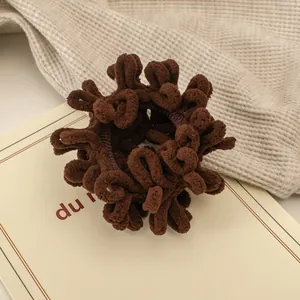 Detailansicht eines dunkelbraunen Plüsch-Haargummis mit weicher Chenille-Textur und Elastizität