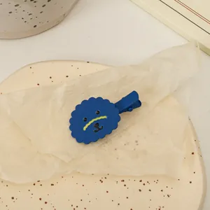 Gros plan détaillé d'une pince à cheveux mate bleue en forme de chien sur un plat décoratif