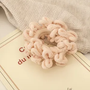 Detailaufnahme der weichen beigen Chenille-Textur auf einem flauschigen Haargummi