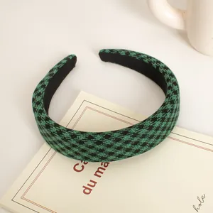 Detail of green and black houndstooth fabric texture on a wide padded headband