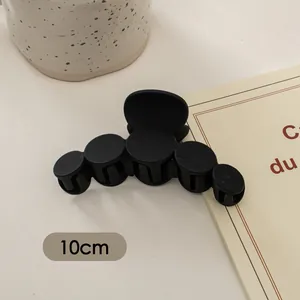 Detailansicht der 10cm großen mattschwarzen Haarklammer mit glattem Fünf-Kreis-Design