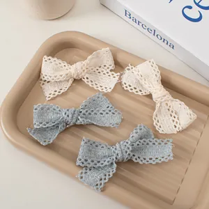 Lot de quatre barrettes à cheveux en dentelle ajourée blanc crème et bleu gris doux