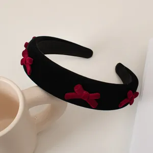 Detailed texture of black velvet headband decorated with burgundy flocked bows