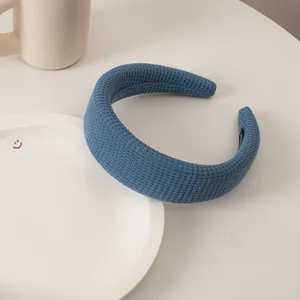 Macro shot of blue waffle knit padded headband on white ceramic tray for hair styling