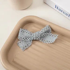 Détail de la pince à cheveux en dentelle bleu clair avec texture tissée ajourée