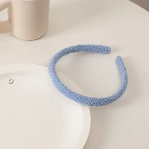 Close-up of light blue knitted headband texture with cozy ceramic tabletop accessories