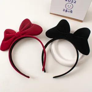 Detailed close-up of velvet bow headbands in elegant red and black for hair styling