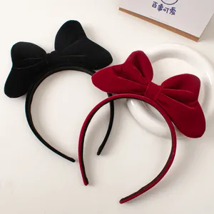 Detailed view of red and black velvet bow headbands on a decorative ceramic tray