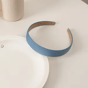 Detail of blue velvet sponge headband with brown non-slip lining on a white desk