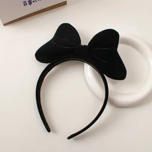 Detail view of the plush black velvet bow on a minimalist and elegant headband for women