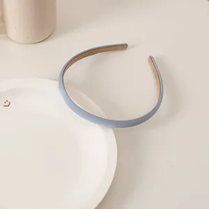 Close-up of light blue minimalist thin headband with matte texture and khaki lining