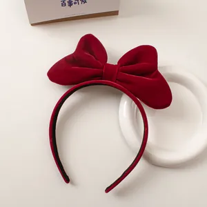 Detail of red velvet bow headband with premium soft texture on a minimal background