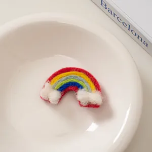 Detailansicht der farbenfrohen Regenbogen-Haarspange aus Wollfilz mit Plüschwolken