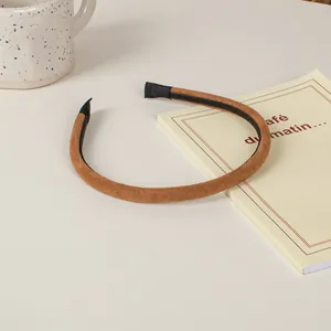 Κοντινή λήψη καφέ σουέτ στέκας μαλλιών με υφασμάτινες άκρες σε μινιμαλιστικό γραφείο