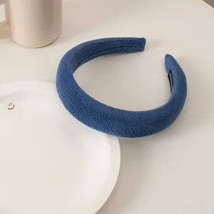 Detail of plush Klein blue sponge headband with soft texture and inner woven label