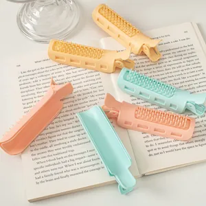 Close-up of pastel root volume hair clips on a book showing the comb teeth and clamp