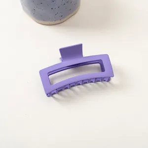 Gros plan sur une pince à cheveux rectangulaire bleu pervenche mat au style épuré