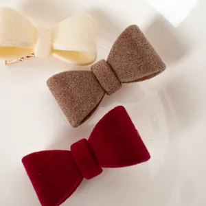 Drei Samt-Schleifen-Haarspangen in Beige, Braun und Weinrot für einen eleganten Look