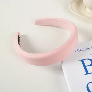 Gros plan d'un serre-tête rembourré rose avec tissu texturé et détail d'étiquette fait main