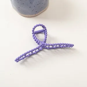 Détail d'une grande pince à cheveux mate lavande avec un design torsadé en spirale