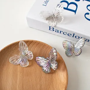 Dettaglio di fermagli per capelli a farfalla laser con ali iridescenti su legno