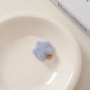 Detailaufnahme einer weichen hellblauen Plüsch-Haarklammer in Sternform auf einem Teller