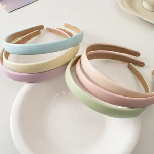 Serre-têtes minimalistes en cuir macaron aux couleurs Morandi sur céramique blanche