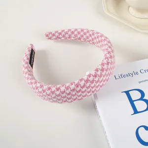 Détail du serre-tête éponge pied-de-poule rose avec étiquette faite main et tissu doux