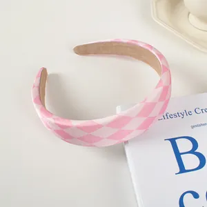 Détail d'un serre-tête à motif losanges rose et blanc avec doublure antidérapante
