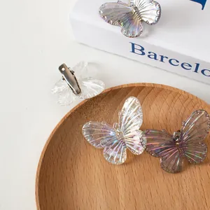 Dettaglio dei fermagli per capelli a farfalla iridescenti con finitura lucida al laser